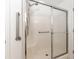 Accessible shower with grab bars and sliding glass doors for safety and convenience at 1212 Chaparral Dr, Lady Lake, FL 32159