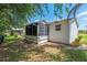 Exterior side view of the home and porch with grass and surrounding trees at 1212 Chaparral Dr, Lady Lake, FL 32159