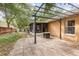 Exterior patio with tile flooring and metal pergola with seating area and decorative lights at 1307 Rain Forest Ln, Minneola, FL 34715
