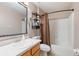 Well-lit bathroom with a vanity sink, mirror, and shower with a curtain at 1307 Rain Forest Ln, Minneola, FL 34715