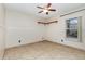 Bright bedroom with neutral walls, a ceiling fan, corner shelves and a large window overlooking the yard at 1307 Rain Forest Ln, Minneola, FL 34715