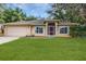 Charming single-story home featuring well-kept landscaping and a welcoming facade with a neatly manicured lawn at 1307 Rain Forest Ln, Minneola, FL 34715