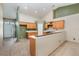 Open kitchen featuring tile floors, wood cabinets, and a breakfast bar area at 1307 Rain Forest Ln, Minneola, FL 34715