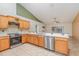Kitchen boasts stainless steel appliances, wood cabinets, and modern countertops at 1307 Rain Forest Ln, Minneola, FL 34715