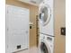 Convenient laundry area with stacked washer and dryer, and plenty of storage space next to a white door at 1307 Rain Forest Ln, Minneola, FL 34715