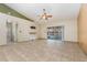 Open living room with tile floors and a sliding glass door at 1307 Rain Forest Ln, Minneola, FL 34715