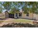 Home's rear exterior shows the screened in porch, fenced yard, and garden at 13301 Biscayne Dr, Grand Island, FL 32735