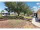 Spacious backyard showcasing mature trees, lawn, garden boxes, storage shed, and fenced perimeter at 13301 Biscayne Dr, Grand Island, FL 32735
