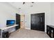 Cozy bedroom with a work desk, dark closet doors, and neutral carpeting at 13301 Biscayne Dr, Grand Island, FL 32735
