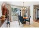 This dining room has a round table with blue chairs and a large window with patterned curtains at 13301 Biscayne Dr, Grand Island, FL 32735