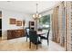 Bright dining room with a round wood table, statement lighting fixture, and natural light from large window at 13301 Biscayne Dr, Grand Island, FL 32735