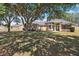 Inviting single-story home featuring manicured landscaping, archway, and a sprawling, shaded front yard at 13301 Biscayne Dr, Grand Island, FL 32735