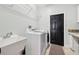Functional laundry room with modern appliances, a utility sink, and ample storage space at 13301 Biscayne Dr, Grand Island, FL 32735