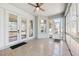 Enclosed sunroom featuring speckled flooring, a ceiling fan, and multiple doors and windows for ample light at 13301 Biscayne Dr, Grand Island, FL 32735