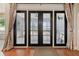 Sunroom featuring floor to ceiling windows, hardwood floor and black framed glass doors at 13301 Biscayne Dr, Grand Island, FL 32735