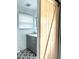 Bathroom with gray vanity, modern black-and-white tile, and natural wood sliding door at 1414 Margate Ave, Orlando, FL 32803