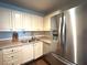 A bright kitchen features stainless steel appliances and updated white cabinets at 1414 Margate Ave, Orlando, FL 32803