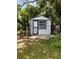 Well-maintained backyard shed with stylish trim, surrounded by lush landscaping and chain-link fence at 1414 Margate Ave, Orlando, FL 32803