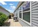 Side patio features table, chair, grill, and views of the yard at 1486 Joshua Ct, The Villages, FL 32163