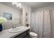 Cozy bathroom features a granite countertop vanity, framed mirror, and decorative shower curtain at 1486 Joshua Ct, The Villages, FL 32163