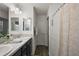 Bathroom with double sink vanity, granite countertops, and decorative shower curtain at 1486 Joshua Ct, The Villages, FL 32163