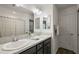 Bathroom features a double sink vanity with granite countertops, framed mirrors and decorative faucet at 1486 Joshua Ct, The Villages, FL 32163