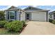 Charming single-Gathering home showcasing a two-car garage, manicured landscaping, and a welcoming entrance at 1486 Joshua Ct, The Villages, FL 32163