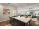 Modern kitchen with granite countertops and an open concept layout into the dining and living area at 1486 Joshua Ct, The Villages, FL 32163