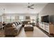 Open living space featuring a large sectional sofa, wood floors, and seamless flow to the dining area and kitchen at 1486 Joshua Ct, The Villages, FL 32163
