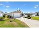 Charming home featuring a well-manicured front yard and a one-car garage for convenient parking at 1486 Olympia St, The Villages, FL 32163
