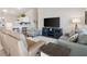 Cozy living area with comfortable seating, a modern TV, and a view into the bright, well-equipped kitchen at 1486 Olympia St, The Villages, FL 32163