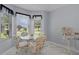 Bright breakfast nook featuring a glass table, cushioned chairs, and abundant natural light from the large windows at 17036 Se 79Th Clearview Ave, The Villages, FL 32162