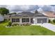 Charming home with a well-maintained lawn, landscaped garden, and a screened two-car garage at 17036 Se 79Th Clearview Ave, The Villages, FL 32162