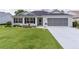 Charming single-story home featuring a well-manicured lawn, screened garage, and inviting front entrance at 17036 Se 79Th Clearview Ave, The Villages, FL 32162