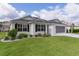Inviting single-story home with a pristine lawn, complemented by a screened garage and lush landscaping at 17036 Se 79Th Clearview Ave, The Villages, FL 32162