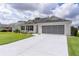 Attractive single-story residence boasting a screened garage, well-maintained lawn, and a welcoming facade at 17036 Se 79Th Clearview Ave, The Villages, FL 32162