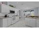 Well-lit kitchen with white cabinetry, elegant countertops, and an adjoining breakfast nook at 17036 Se 79Th Clearview Ave, The Villages, FL 32162