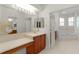 Bathroom features large mirror, wood vanity, tiled floors, and a view of tub and shower at 1721 Sunset Ridge Dr, The Villages, FL 32162