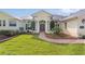 Welcoming entrance with mature landscaping and elegant columns frames the front door at 1721 Sunset Ridge Dr, The Villages, FL 32162