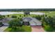Lovely home with a two-car garage, mature landscaping, and brick paved driveway overlooking the golf course and water at 1721 Sunset Ridge Dr, The Villages, FL 32162
