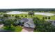 Charming house with a two-car garage, landscaped yard, and brick paved driveway with views of the golf course and water at 1721 Sunset Ridge Dr, The Villages, FL 32162