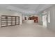 Open living room with tile floors, tray ceiling with fan, view of kitchen and patio at 1721 Sunset Ridge Dr, The Villages, FL 32162