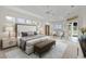 Bright and airy main bedroom with tray ceiling, ceiling fan, and seating area at 1721 Sunset Ridge Dr, The Villages, FL 32162