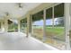 Enclosed patio with large windows showcasing lush green landscape and a scenic golf course view at 1721 Sunset Ridge Dr, The Villages, FL 32162
