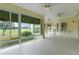 Expansive patio featuring large windows with golf course views, tiled floors, and multiple ceiling fans at 1721 Sunset Ridge Dr, The Villages, FL 32162