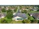 Rear view of home in residential neighborhood with a green lawn and mature trees at 1721 Sunset Ridge Dr, The Villages, FL 32162