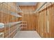 Wood paneled walk-in closet features multiple rows of white, wire shelving at 1721 Sunset Ridge Dr, The Villages, FL 32162