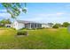 Well-maintained backyard with green grass, manicured landscaping, and an enclosed lanai at 17587 Se 95Th Cir, Summerfield, FL 34491
