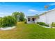 Lush backyard featuring well-maintained lawn, landscaping, and a covered patio at 17587 Se 95Th Cir, Summerfield, FL 34491