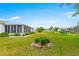 Green backyard showing the house with an enclosed lanai and landscaped gardens at 17587 Se 95Th Cir, Summerfield, FL 34491